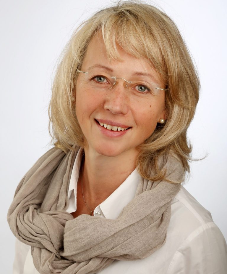 Porträt einer lächelnden Frau mit blonden Haaren 